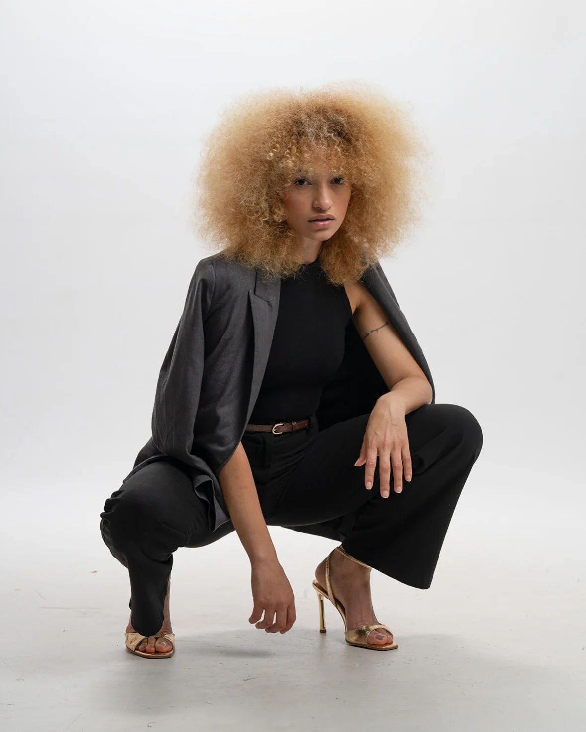 Nalu seated in a black look against a light studio background.