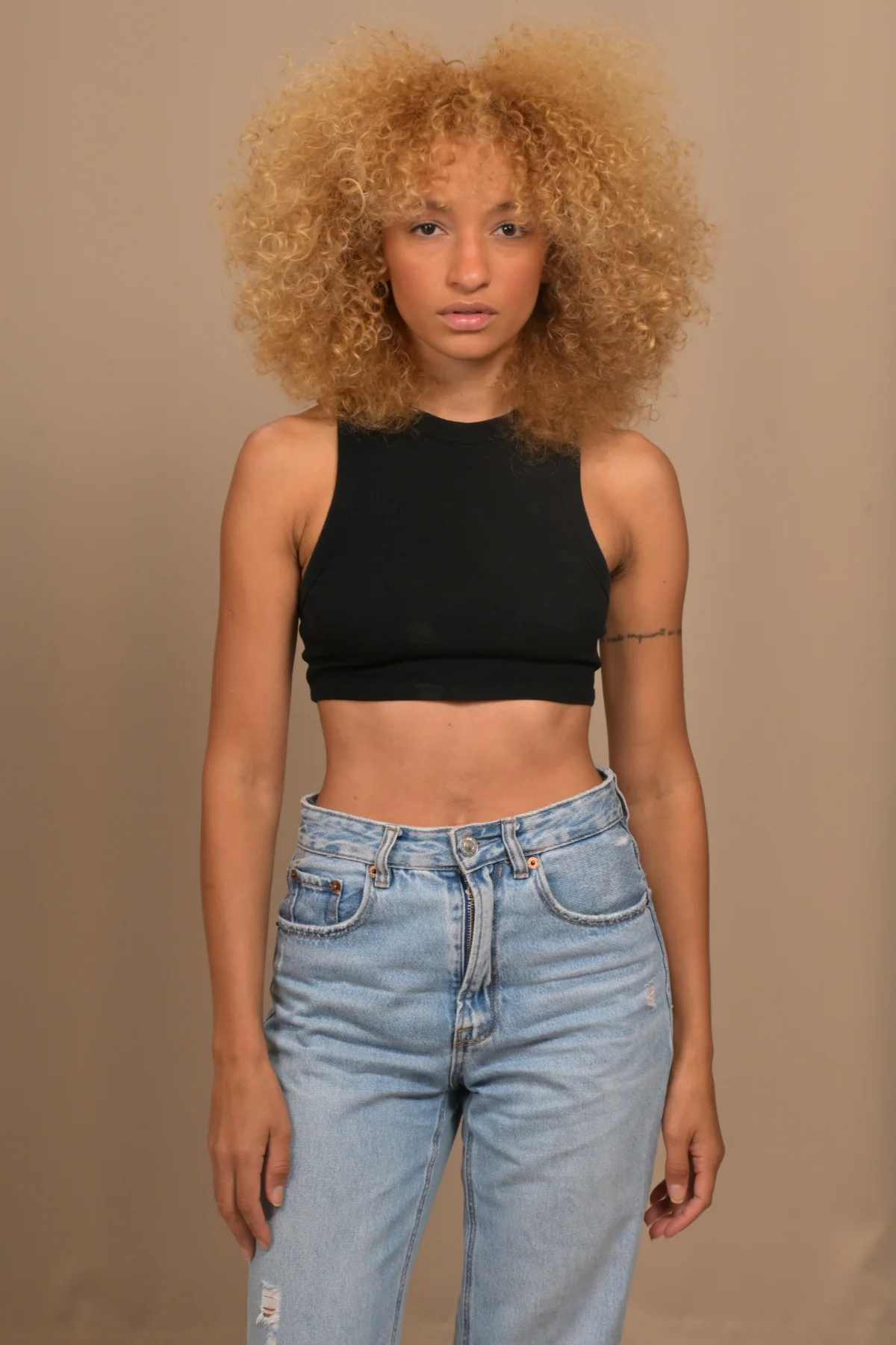 Front-facing full-length portrait of Nalu wearing a black top and jeans.